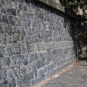 Steinmauer mit eingeschlagenen Nägeln 