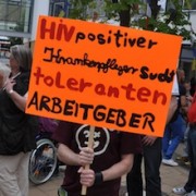 Demonstrationsschild, auf dem toleranter Umgang mit HIV-positiven Krankenpflegern gefordert wird