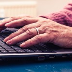 alte Frau arbeitet am Laptop