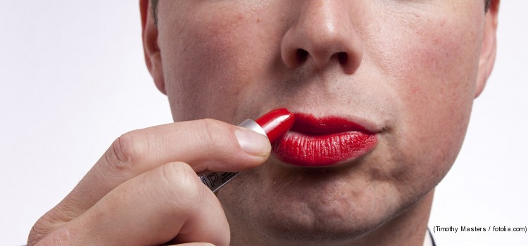 Mann schminkt sich die Lippen