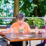 Gruppe von Seniorinnen spielt Karten.