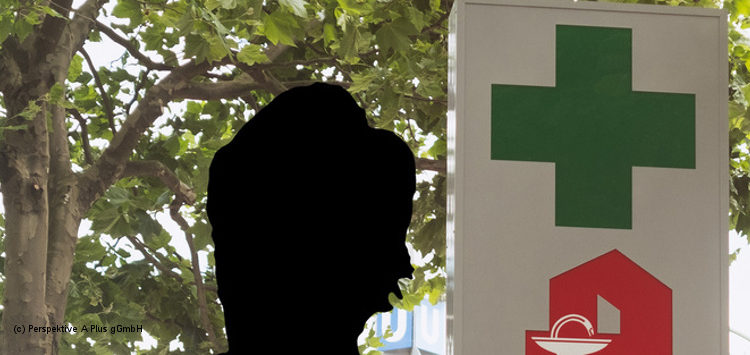 Eine anonyme Person vor einem Apotheken-Schild