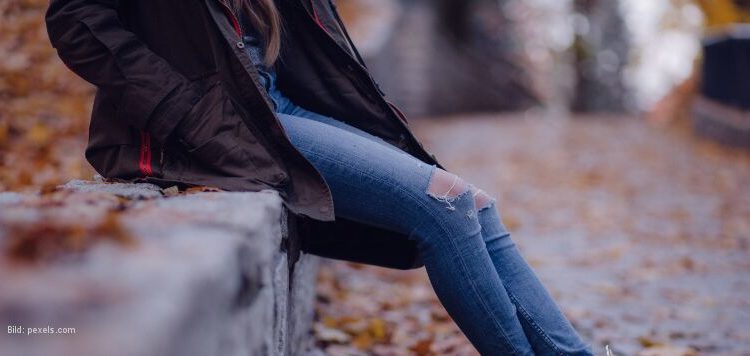 Sitzende Frau in Herbstlandschaft