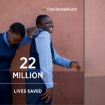 Zwei lachende Mädchen in Schuluniform stehen vor einer braunen Wand, davor der Text "22 million lives saved", oben das Logo des Global Fund.