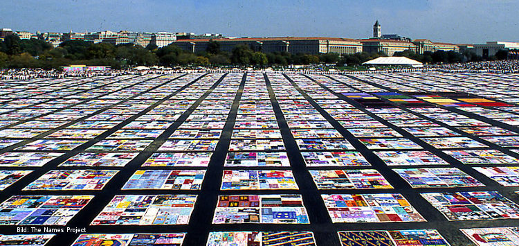 Eine große Masse ausgebreiteter bunter Tücher, die AIDS Memorial Quilt genannt werden und an Menschen erinnern, die an Aids gestorben sind