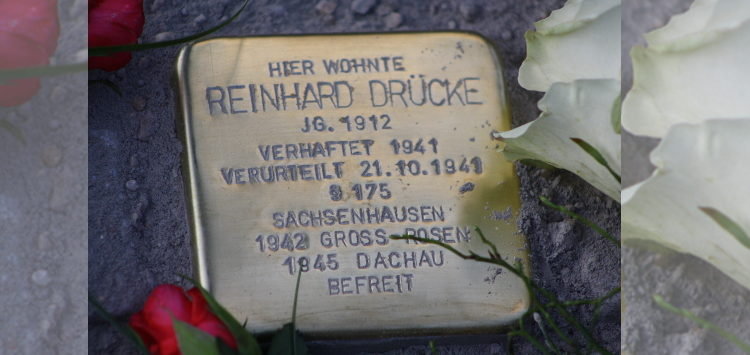 Ein Stolperstein im Straßenpflaster, mit dem Text "Hier wohnte Reinhard Drücke."
