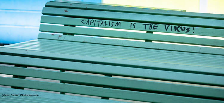 protest message against capitalism and the corona virus is written on a bench. outdoors