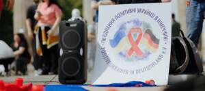 Logo des Vereins PlusUkrDe auf einem Schild bei einem Protest vor dem BRandenburger Tor in Berlin (Foto: Johannes Grill)