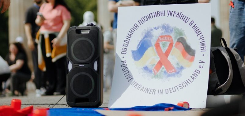 Logo des Vereins PlusUkrDe auf einem Schild bei einem Protest vor dem BRandenburger Tor in Berlin (Foto: Johannes Berger)