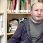 Porträt Dmitry Subtselny vor Bücherwand am Tisch sitzend