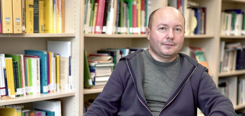 Porträt Dmitry Subtselny vor Bücherwand am Tisch sitzend