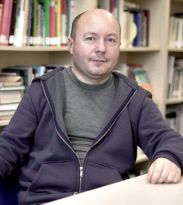 Porträt Dmitry Subtselny vor Bücherwand am Tisch sitzend