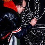 Keith Haring zeichnet ein Graffito an eine Wand. Standbild aus dem Film "The Universe of Keith Haring".