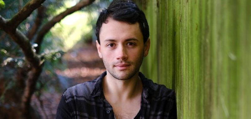 Porträt des Autors neben einer grünen Wand