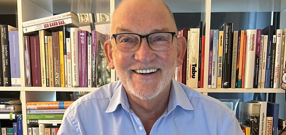 Porträt von Hans-Gerd Brunnert vor einem Bücherregal