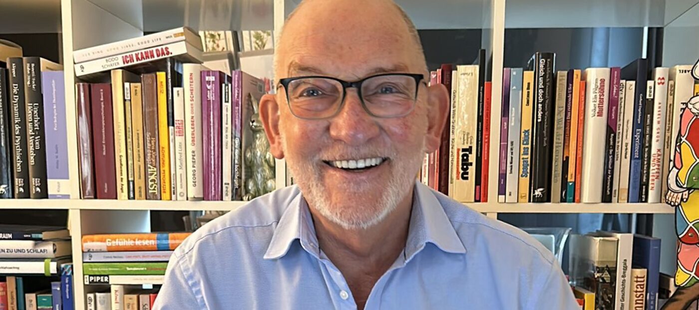 Porträt von Hans-Gerd Brunnert vor einem Bücherregal