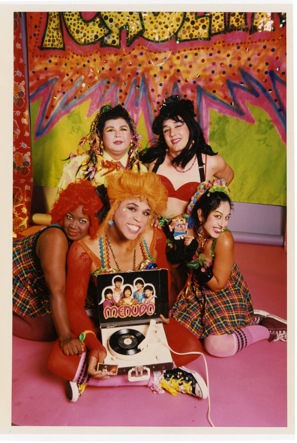 farbenfrohes Bandfoto mit der Künstlerin und 4 weiteren Frauen vor einem Plattenspieler