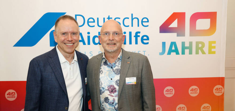 Dirk Meyer mit Volker Mertens vor einem Banner zu 40 Jahre DAH