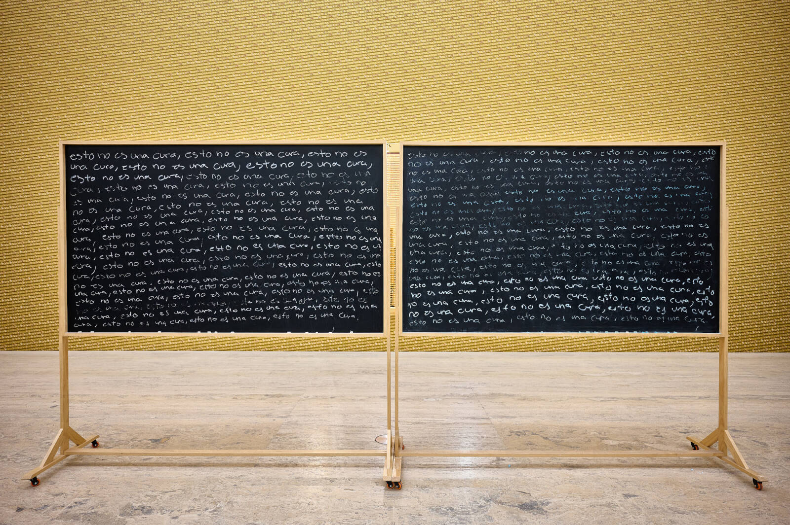 Zwei unlesbar dicht beschriebene Schultafeln in einem sonst leeren Raum