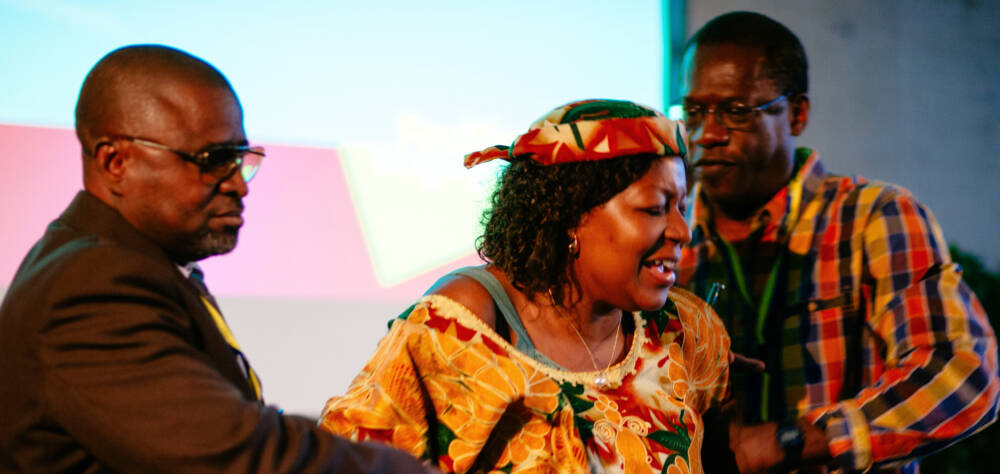 drei Personen interagieren bei einer Theateraufführung