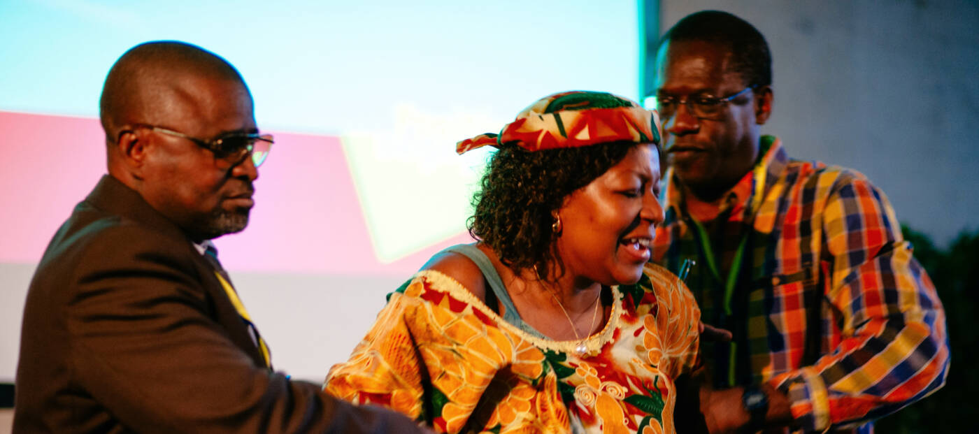 drei Personen interagieren bei einer Theateraufführung