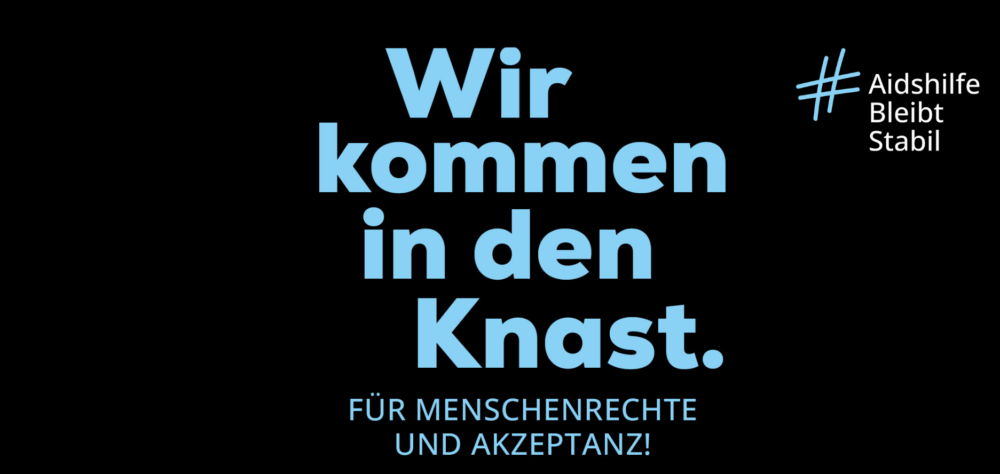 Blaue Schrift auf schwarzen Hintergrund: Wir kommen in den Knast. Für Menschenrechte und Akzeptanz! Hashtag Aidshilfe Bleibt Stabil. Deutsche Aidshilfe