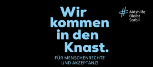Blaue Schrift auf schwarzen Hintergrund: Wir kommen in den Knast. Für Menschenrechte und Akzeptanz! Hashtag Aidshilfe Bleibt Stabil. Deutsche Aidshilfe